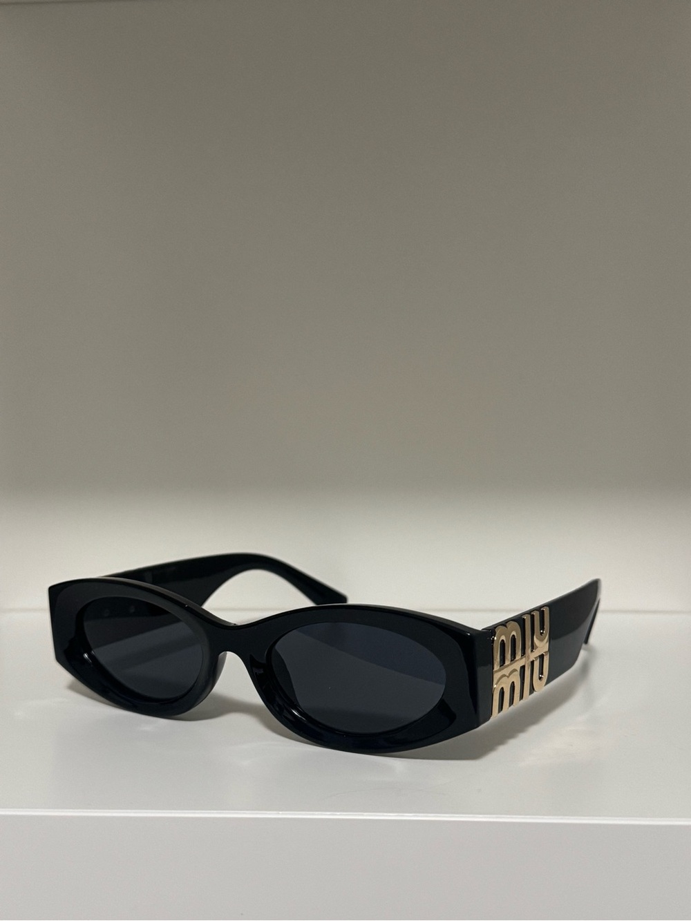 Miu Miu Black Oval Sunglasses with Gold Logo Temples